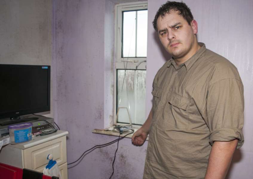 Connor Cowling pictured with mould in his living room
