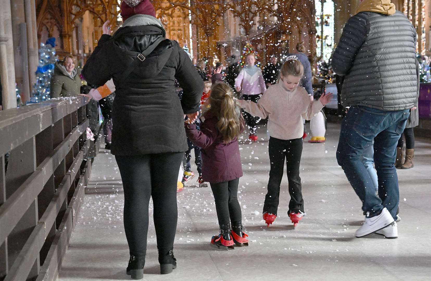 Visitors enjoying the St Wulfram's Christmas Tree Festival and skating rink.