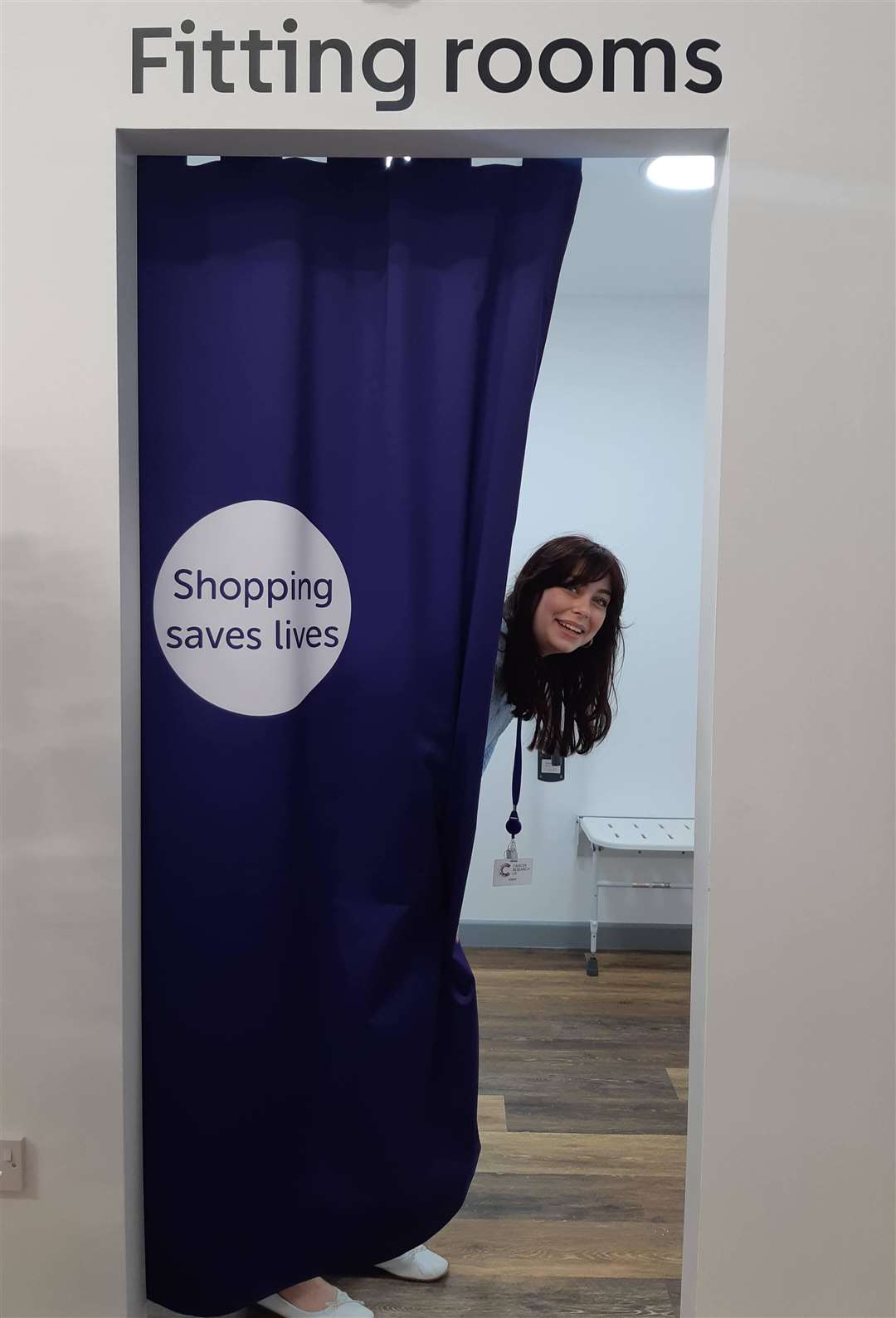 Shop assistant Clarice Deakin shows off the spacious changing room that caters for prams and people using mobility aids
