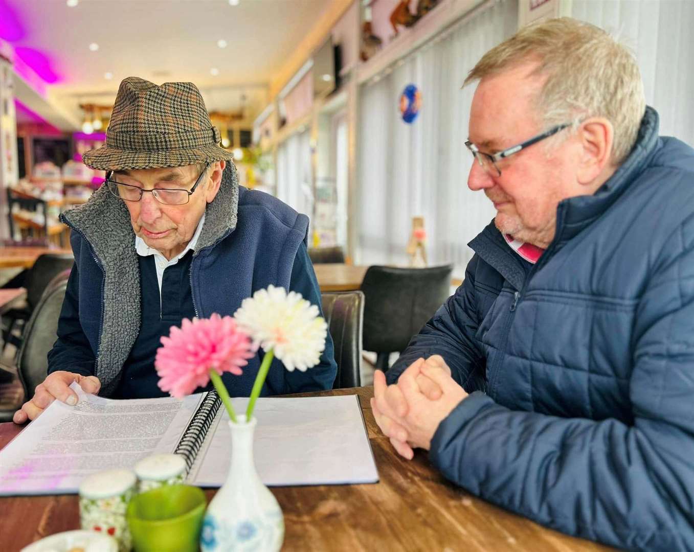 Michael (left) reads through a piece written by his manager about their Falklands days