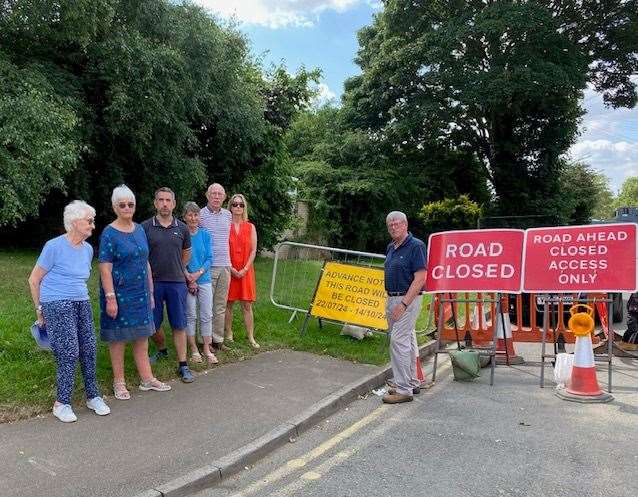 Andrew Boyce (right) with Cricket Lawns residents next to the Brooke Road closure sign in Oakham