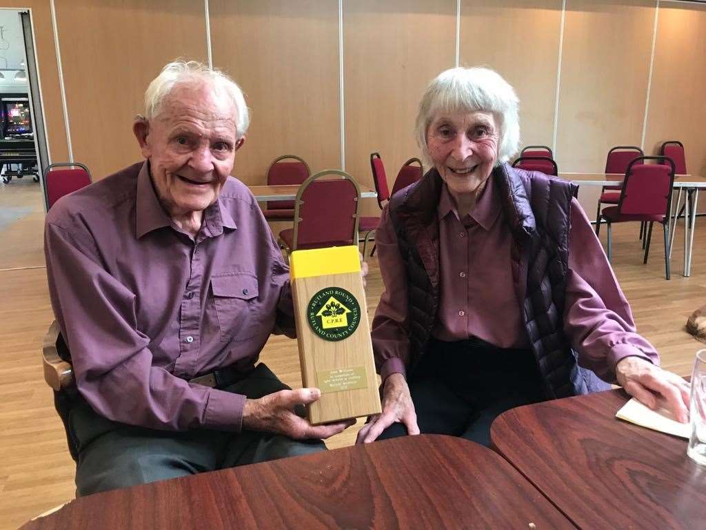 John and Trisha Williams with the special gift presented by Rutland Ramblers, crafted to resemble a waymarker from the Rutland Round