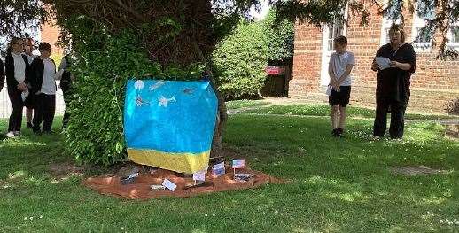 Pupils and staff at Holbeach Bank Academy gather around the yew tree to remember those who served in D-Day PHOTO: SUPPLIED