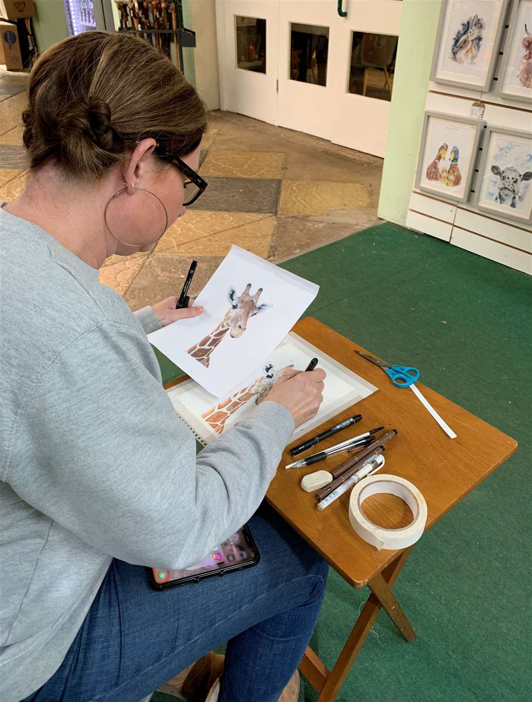 Artist Katie Ford works on one of her pictures