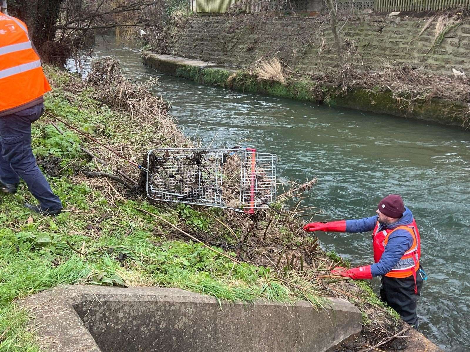 Volunteers removing a trolley from the river.