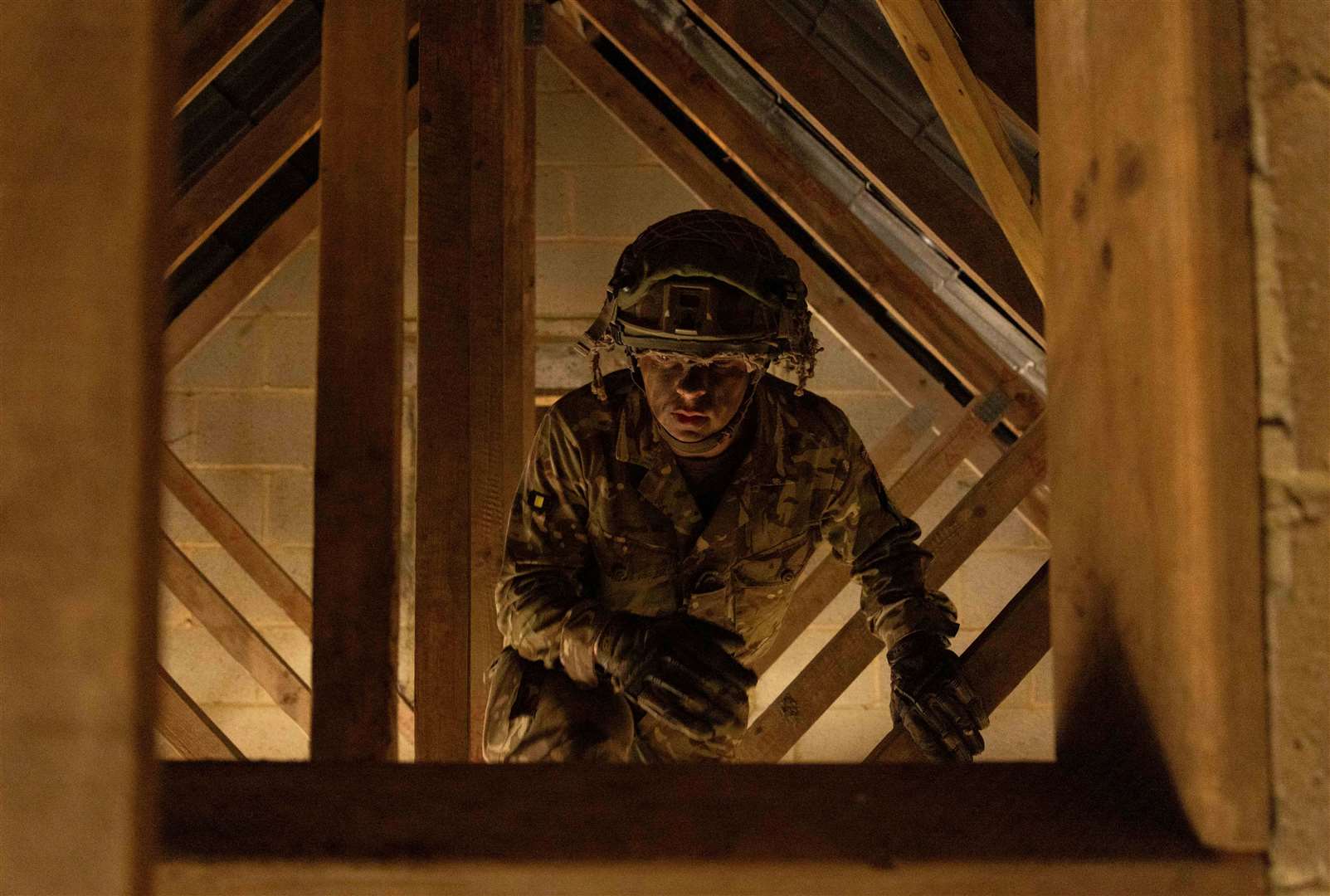 Private Warren crawls through roof rafters.