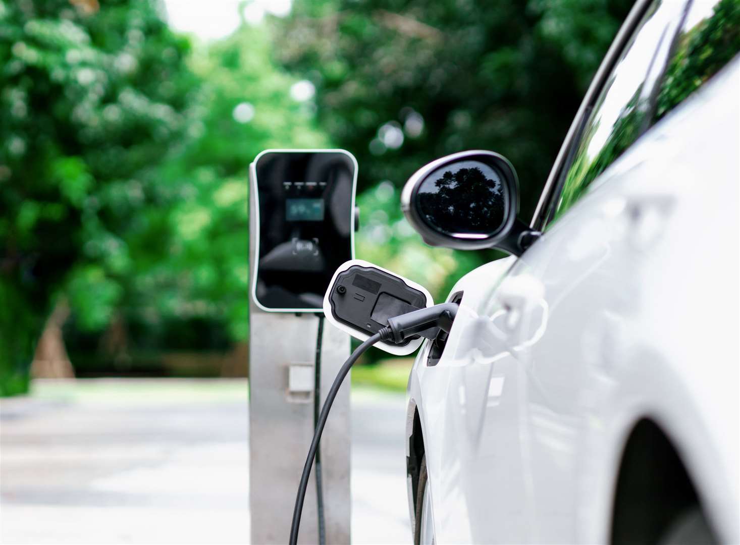 Electric vehicle plugged in with EV charger device. Photo: istock