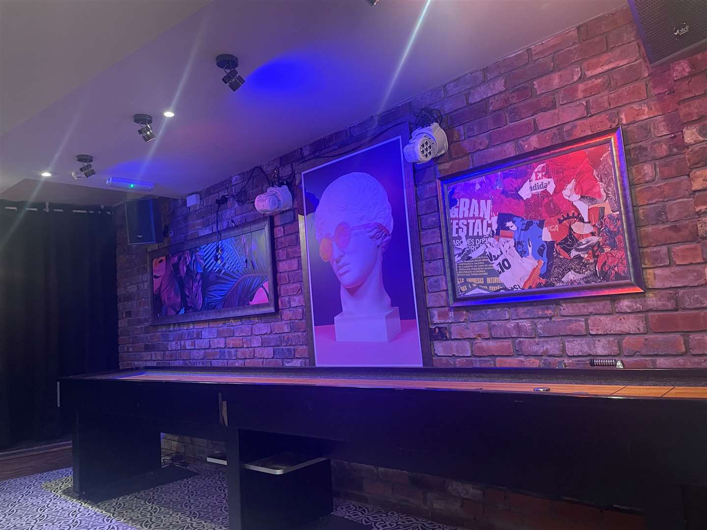 Pop art adorned the walls above the shuffleboard table