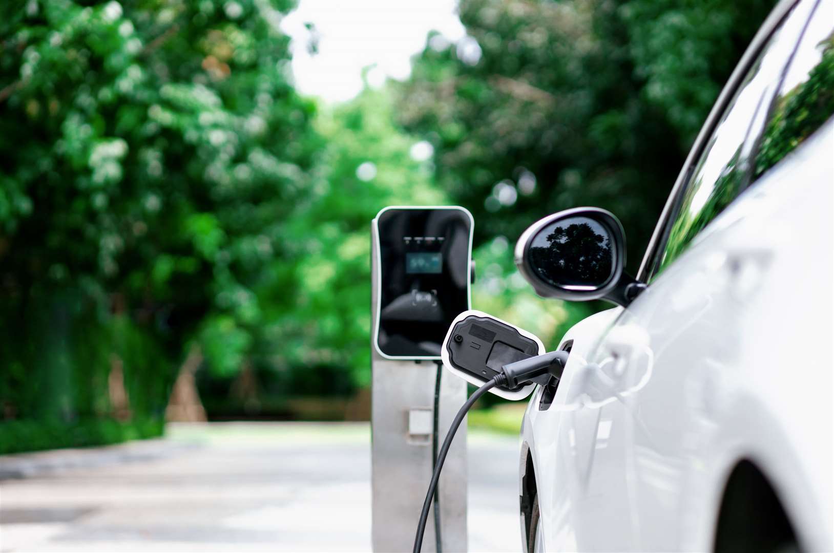 Electric vehicle plugged in with EV charger device. Photo: istock